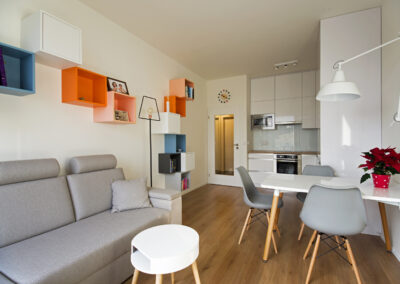 jídelní stůl, jídelní židle, pohovka, malá kuchyň, barevné police