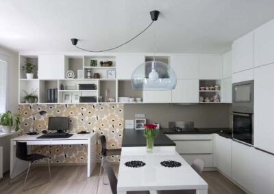 Interiér panelákového bytu, Marimekko, tapeta, kuchyň, kuchyňská linka, jídelní stůl, police, pracovní stůl, závěsné světlo