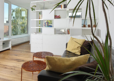 Byt v novostavbě, knihovna, pohovka, konferenční stolky, dřevěná podlaha