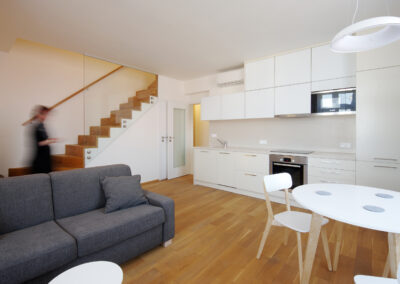 Obytný prostor, kuchyň, kuchyňská linka, jídelní, stůl, židle, schodiště, dřevěná podlaha