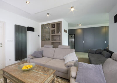 Proměna obývacího pokoje, RD Nučice, pohovka, křeslo, starožitní konferenční stolek, vestavěné bodové osvětlení, vertikální antracitový radiátor, vestavěné police v nice