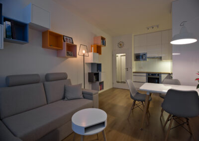 jídelní stůl, jídelní židle, pohovka, malá kuchyň, barevné police