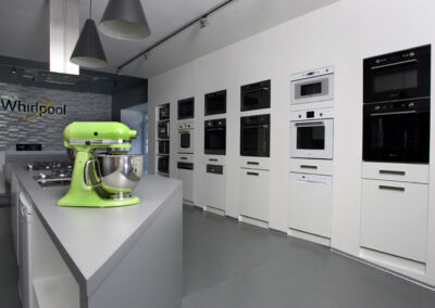 Největší showroom, zn. Whirlpool, prodejna, komerční prostor, komerční interiér, prodejní pult, spotřebiče, šedá podlaha, litá podlaha, vestavěné spotřebiče, tapeta, závěsná světla