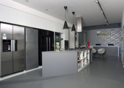 Největší showroom, zn. Whirlpool, prodejna, komerční prostor, komerční interiér, prodejní pult, spotřebiče, šedá podlaha, litá podlaha, lednice, mixéry, tapeta, závěsná světla