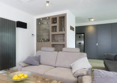 Proměna obývacího pokoje, RD Nučice, pohovka, křeslo, starožitní konferenční stolek, vestavěné bodové osvětlení, vertikální antracitový radiátor, vestavěné police v nice