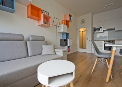 jídelní stůl, jídelní židle, pohovka, malá kuchyň, barevné police