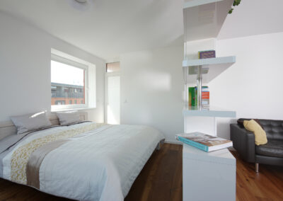 Byt v novostavbě, knihovna, postel, dřevěná podlaha, okno