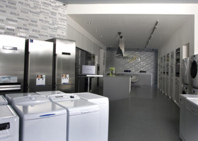 Největší showroom, zn. Whirlpool, prodejna, komerční prostor, komerční interiér, prodejní pult, spotřebiče, šedá podlaha, litá podlaha, lednice, mixéry, pračky, tapeta, závěsná světla