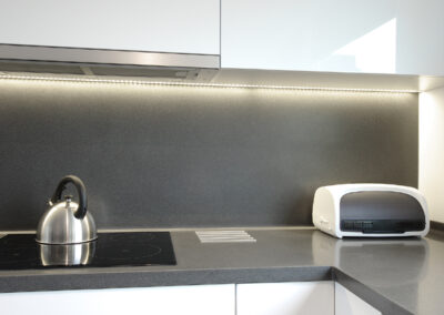 Panelákový byt, kuchyň, kuchyňská linka, tmavá deska, bílá kuchyň, indukční deska