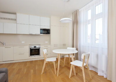 Luxusní byt, kuchyň, jídelní židle, jídelní stůl, sklo v kuchyni, dřevěná podlaha