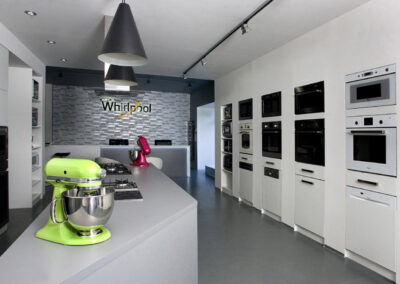 Největší showroom, zn. Whirlpool, prodejna, komerční prostor, komerční interiér, prodejní pult, spotřebiče, šedá podlaha, litá podlaha, vestavěné spotřebiče, tapeta, závěsná světla, hnětač, mixér