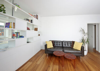 Byt v novostavbě, knihovna, pohovka, konferenční stolky, dřevěná podlaha