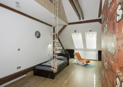 Dětské pokoje v podkroví, klučičí pokoj, teenager pokoj, tapeta streetart, dřevěná podlaha, postel, audio křeslo, bunkr, provazový žebřík, počítačový stůl