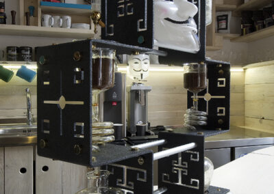 Interiér kavárny AnonymouS, dřevěný nábytek, dřevěný pult, modré pruhy, přístroj pro filtraci