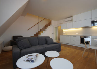 Obytný prostor, kuchyň, kuchyňská linka, jídelní, stůl, židle, schodiště, dřevěná podlaha