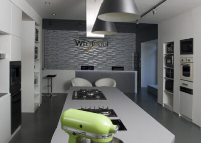 Největší showroom, zn. Whirlpool, prodejna, komerční prostor, komerční interiér, prodejní pult, spotřebiče, šedá podlaha, litá podlaha, vestavěné spotřebiče, tapeta, závěsná světla