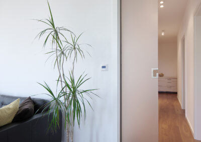 Byt v novostavbě, knihovna, pohovka, konferenční stolky, dřevěná podlaha, posuvné dveře