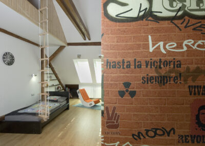 Dětské pokoje v podkroví, klučičí pokoj, teenager pokoj, tapeta streetart, dřevěná podlaha, postel, audio křeslo, bunkr, provazový žebřík, počítačový stůl