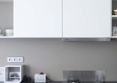 Interiér panelákového bytu, Marimekko, tapeta, kuchyň, kuchyňská linka, jídelní stůl, kuchyň do U, tmavá deska, bílá kuchyň