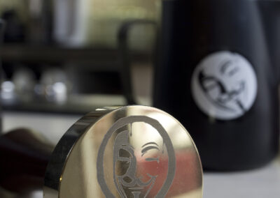 Interiér kavárny AnonymouS, hrnek na mléko, tamper s logem AnonymouS