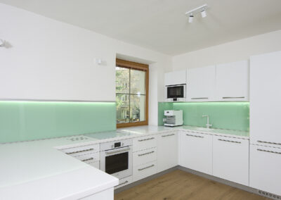 Řadový dům, kuchyň, kuchyňská linka, zelené sklo, bílá kuchyň, okno v kuchyni, dřevěná podlaha