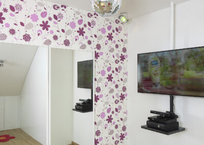 Dětské pokoje v podkroví, dívčí pokoj, květinová tapeta, dřevěná podlaha postel, křeslo, psací stůl, židle, růžový pokoj