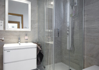 Rekonstrukce, rodinný dům, přízemí, koupelna, sprchový kout, umyvadlo se skříňkou, zrcadlo, osvětlení v koupelně, sprchový panel, záchod, WC, šedý obklad