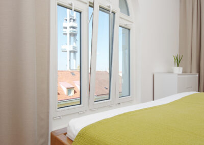 Luxusní byt, ložnice, velká okna, Žižkovská věž, výhled z okna, závěs