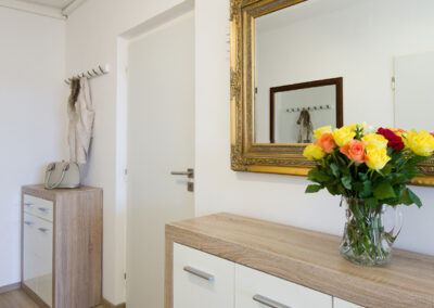 Panelákový byt, chodba, komoda, zrcadlo, dekorativní rám, zrcadlo ve zlatém rámu, vinylová podlaha