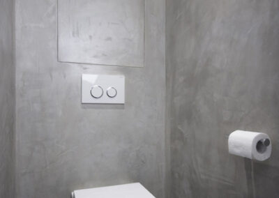 Interiér bytu Řešovská, panelákový byt, kompletní rekonstrukce, WC, záchod, šedá cementová stěrka, tlačítko na splachování držák na papír