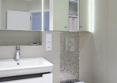 Panelákový byt, koupelna, radiátor, umyvadlo, zrcadlo, záchod, WC, nerezová mozaika, béžový obklad, vinylové dílce, vinylová podlaha