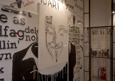 Interiér baru AnonymouS, tmavé dřevo, logo na zdi, nápisy na zdi, vstupní hala, vstup na WC, pomalované dveře