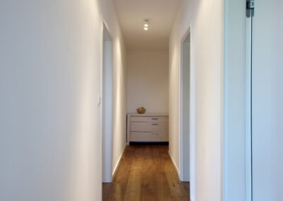 Byt v novostavbě, chodba, dřevěná podlaha, dveře