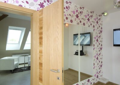 Dětské pokoje v podkroví, dívčí pokoj, květinová tapeta, dřevěná podlaha postel, křeslo, psací stůl, židle, růžový pokoj