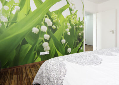 Panelákový byt, Zlín, zelená tapeta, konvalinky, tapeta, ložnice, vinylová podlaha, závěs