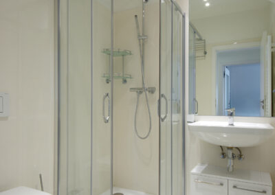 Luxusní byt, koupelna, béžové obklady, umyvadlo, zrcadlo, sprch, sprchový kout