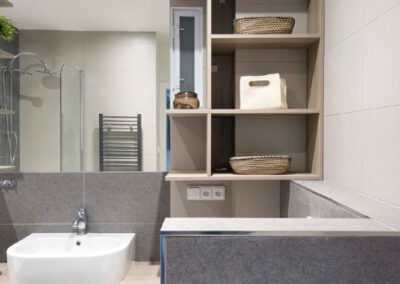 Interiér cihlového bytu, koupelna, nábytek v koupelně, velké zrcadlo, vana, umyvadlo, nábytek pod umyvadlem, police v koupelně