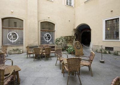 Interiér baru AnonymouS, venkovní sezení, sezení v atriu, polepené okno